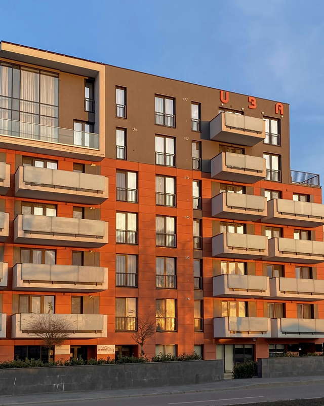Warm evening light across the balconies of a low rise apartment building