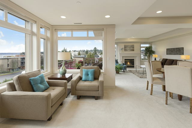 An open plan living and dining room with corner windows and a gas fireplace, turned over between tenancies
